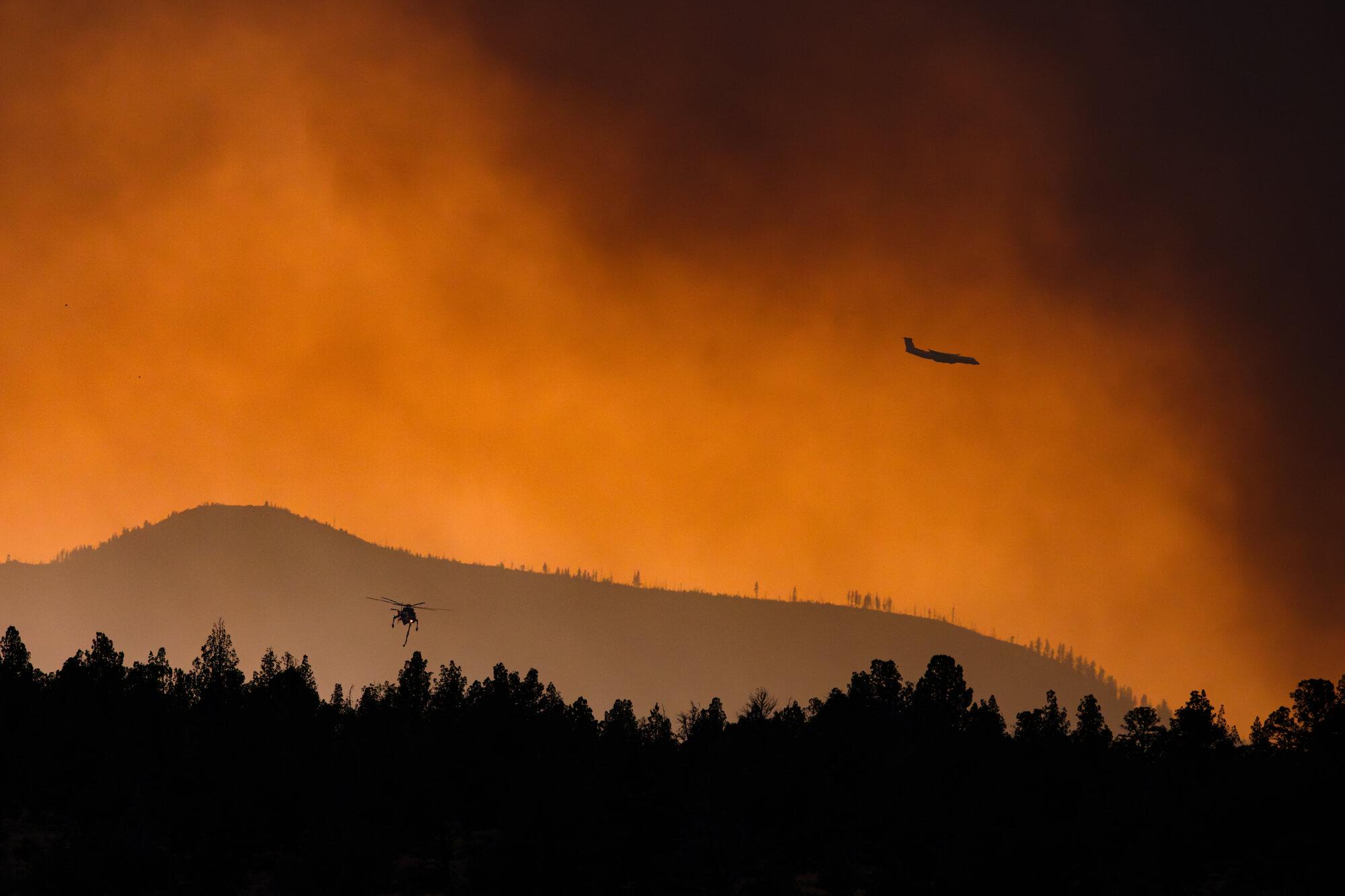 Helicopters work to aid efforts agains the 2025 Flat Fire