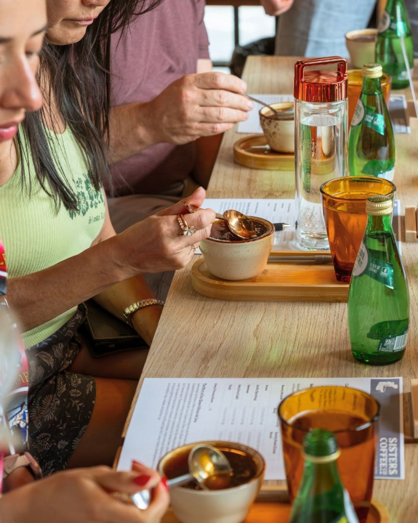 People sitting at a wooden table eating small bowls of food with spoons in Central Oregon.