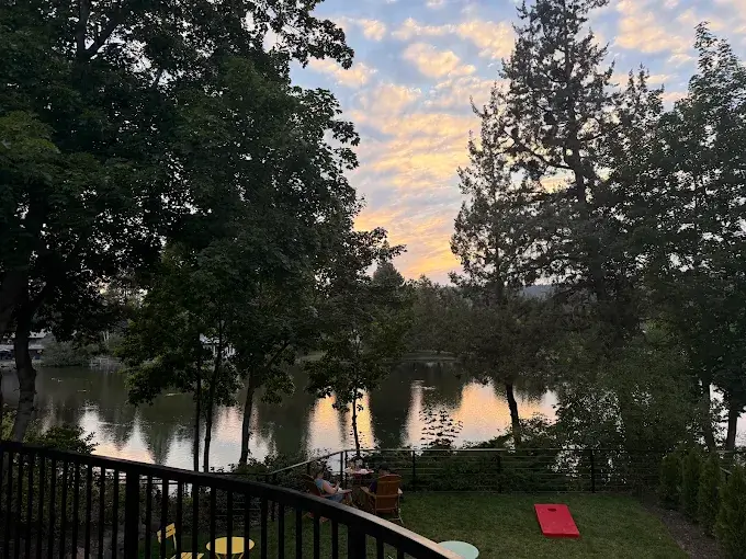 People relax in a backyard overlooking a calm lake during a beautiful sunset in Central Oregon.