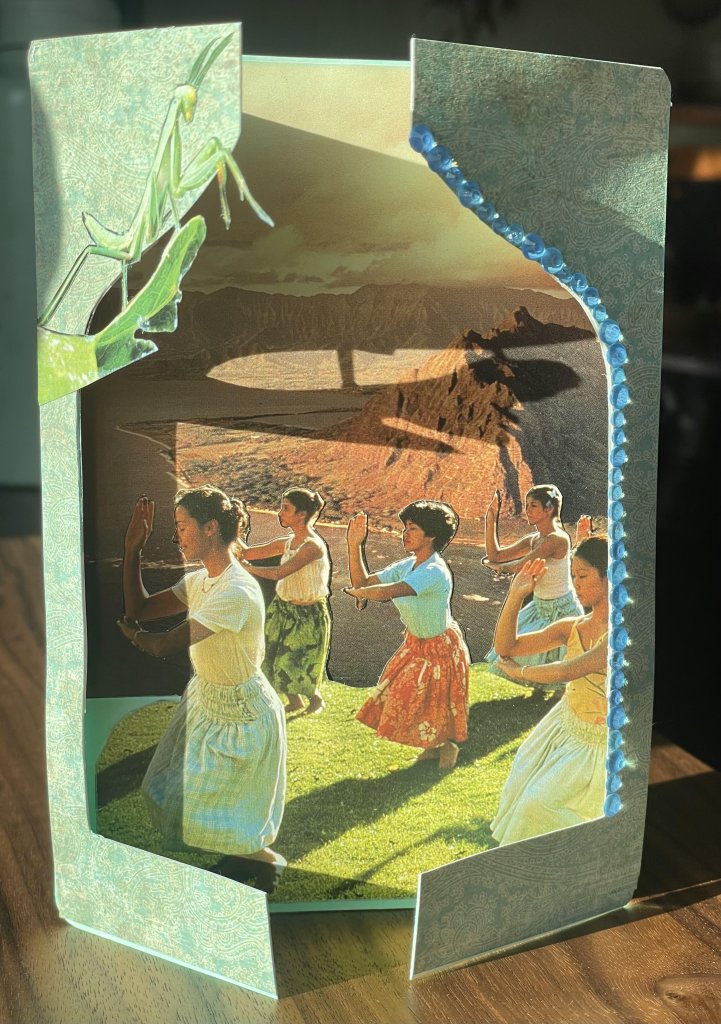 A layered paper craft featuring hula dancers in front of a mountain landscape in Central Oregon.