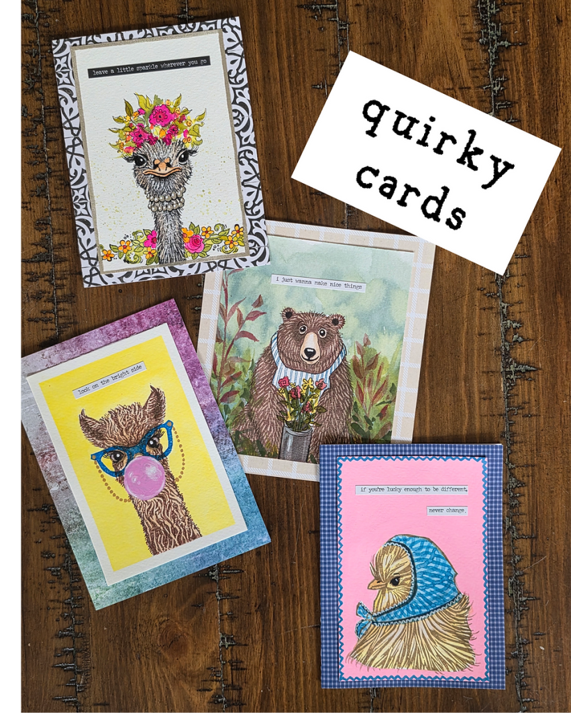Four handmade greeting cards with animal illustrations arranged on a wooden surface in Central Oregon.
