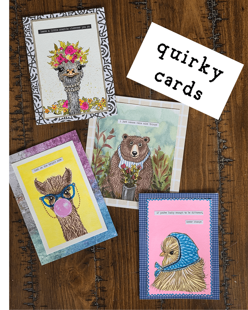 Four handmade greeting cards with animal illustrations arranged on a wooden surface in Central Oregon.