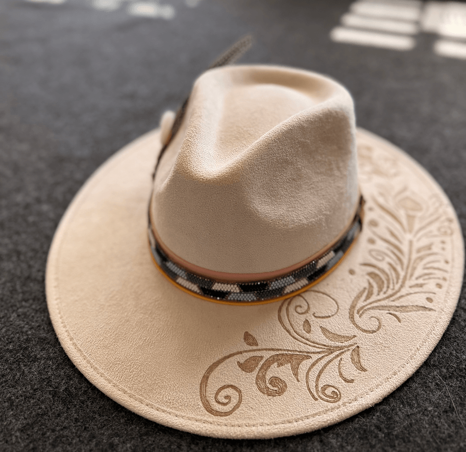 A beige felt fedora with a beaded band and intricate floral embroidery on the brim in Central Oregon.