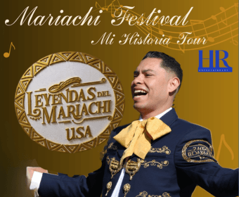 A smiling mariachi singer performing in front of a golden festival promotional poster in Central Oregon.