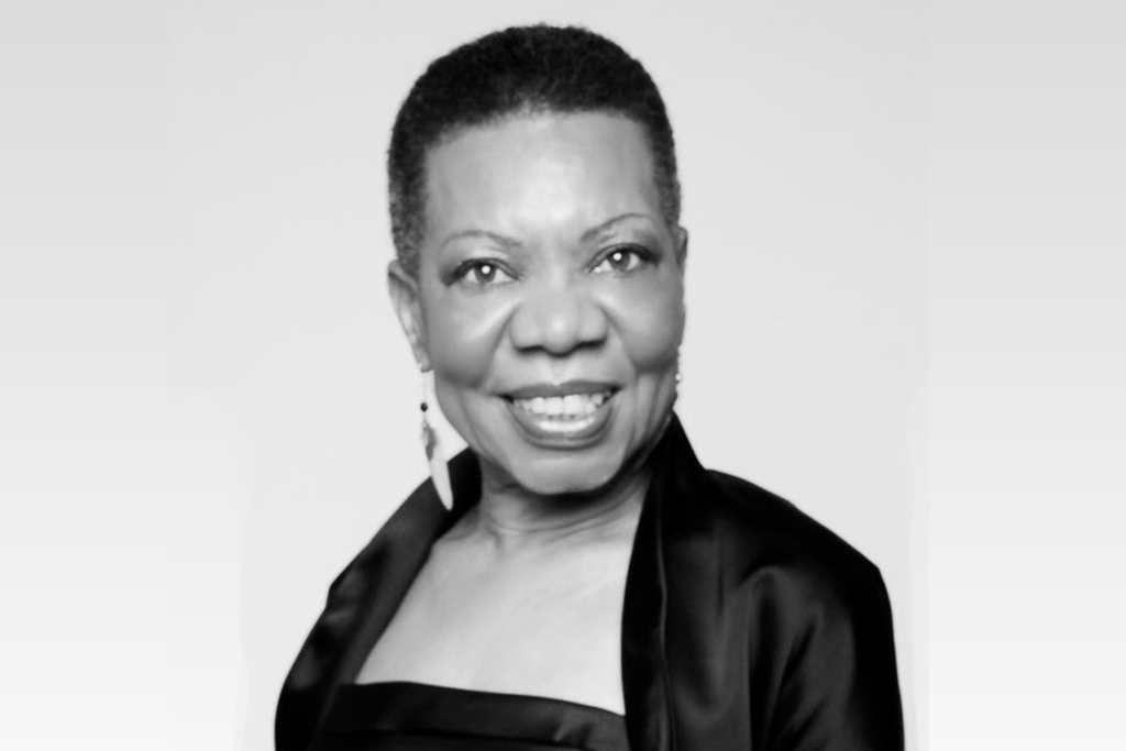 A black and white portrait of a smiling woman with short hair in Central Oregon.