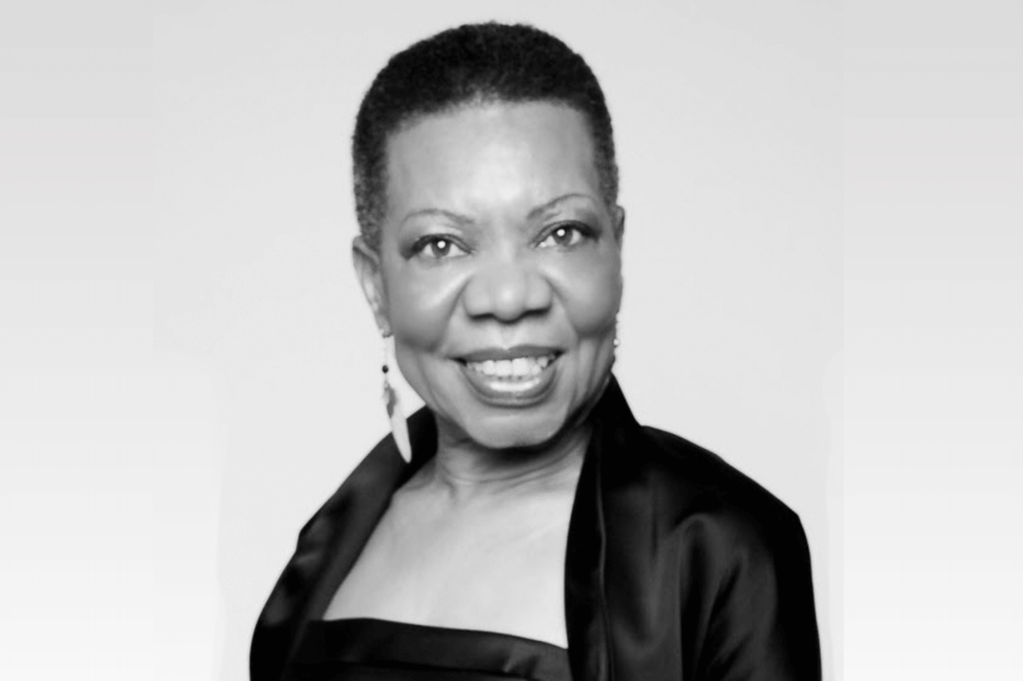 A black and white portrait of a smiling woman with short hair in Central Oregon.