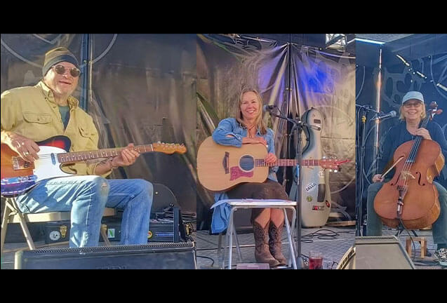 Three musicians performing on stage with an electric guitar, acoustic guitar, and cello in Central Oregon.