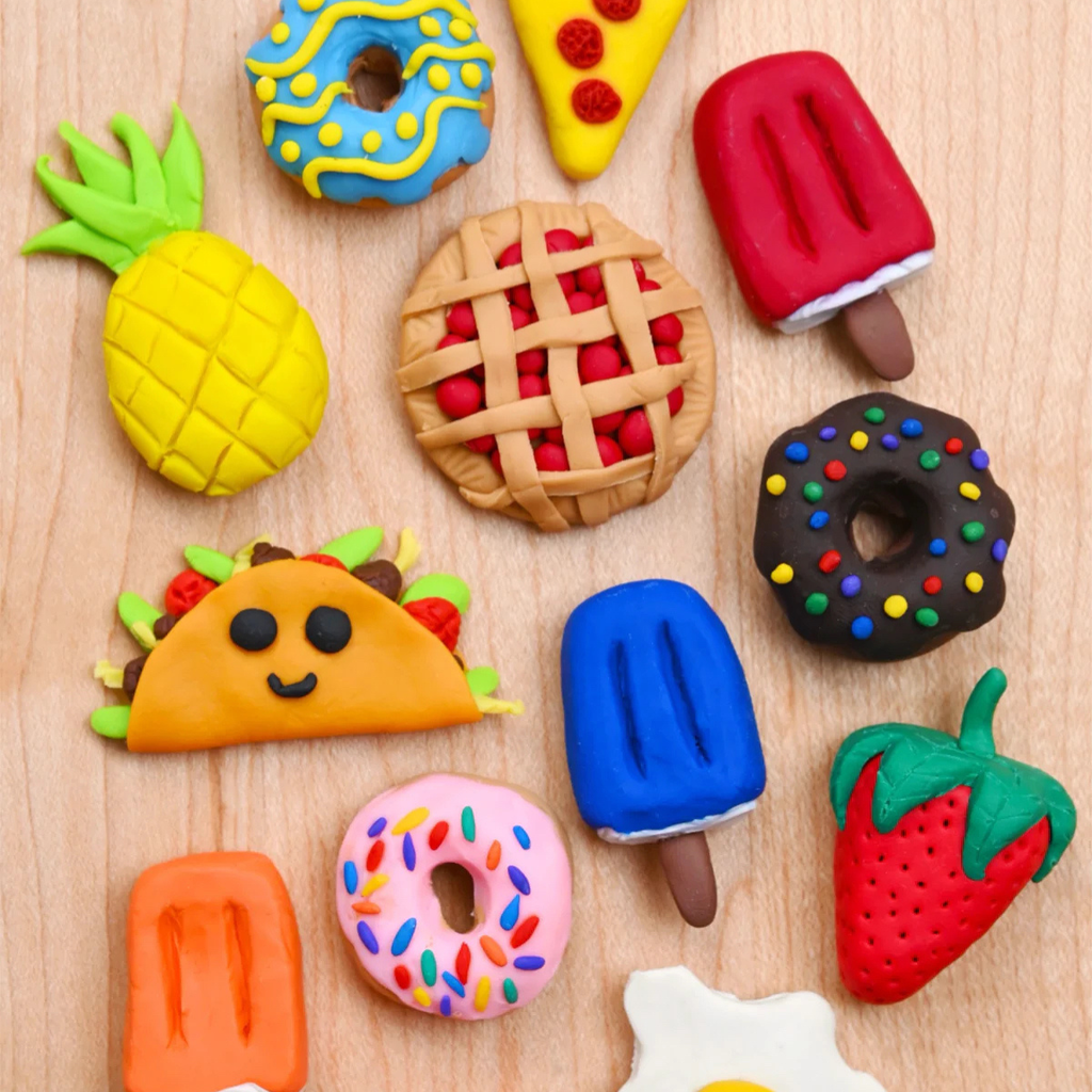 Various colorful food items made of clay arranged on a wooden surface in Central Oregon.