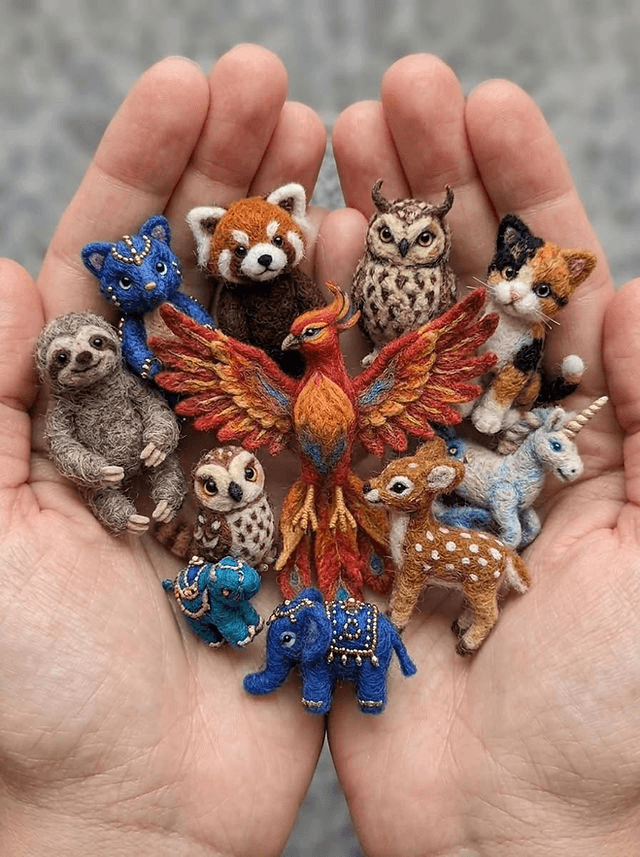 A pair of hands holding a collection of tiny, intricate needle-felted animal figurines in Central Oregon.
