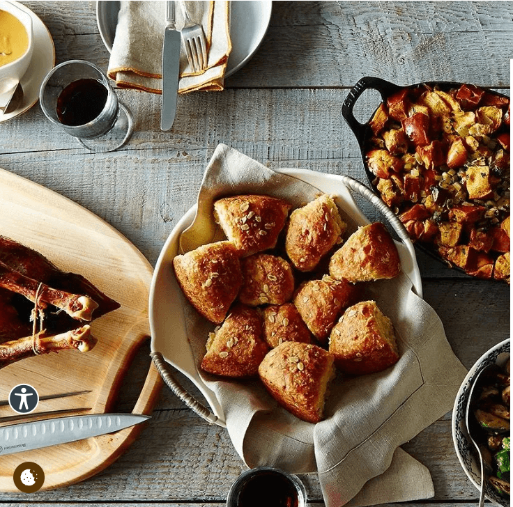 A rustic table setting featuring a basket of bread rolls and a roasted bird in Central Oregon.