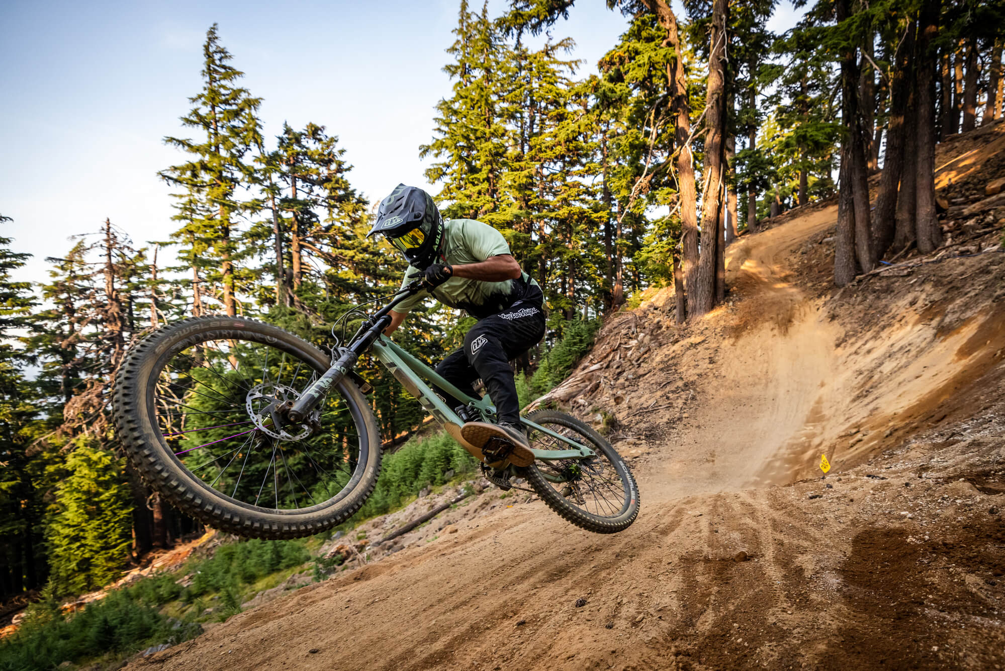 A mountain biker jumps over a dirt trail in a forest in Central Oregon.