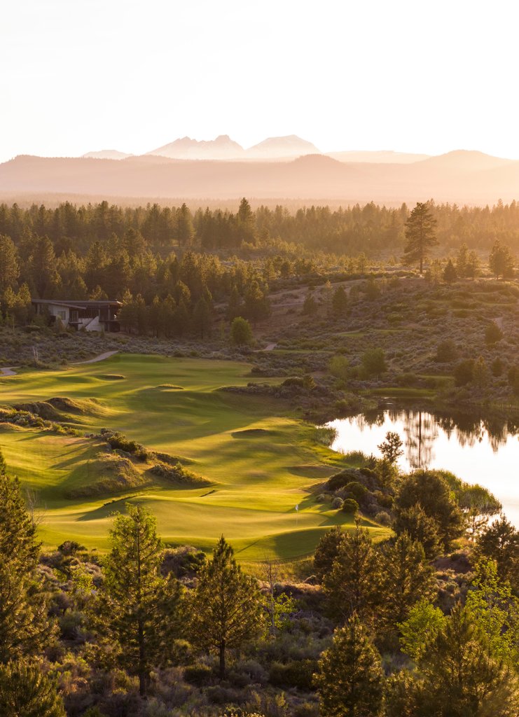 A scenic golf course landscape at sunset with mountains in the background in Central Oregon.