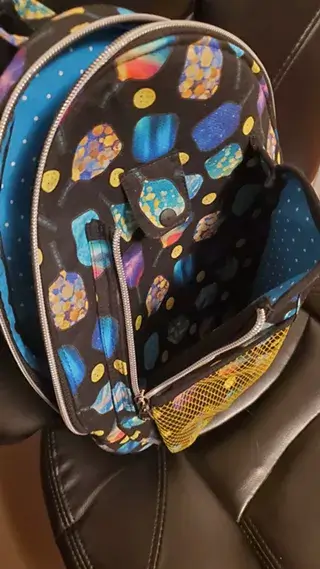 A black backpack with a colorful paddle pattern and blue polka dot interior lining in Central Oregon.