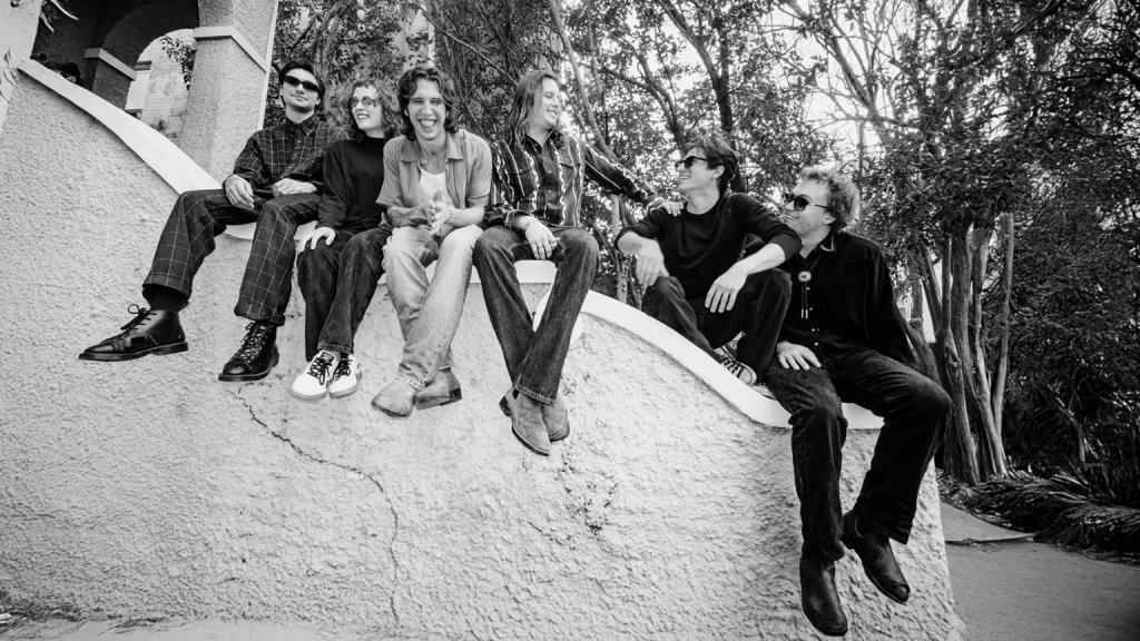 A group of six young people sitting on a curved wall outdoors in Central Oregon.
