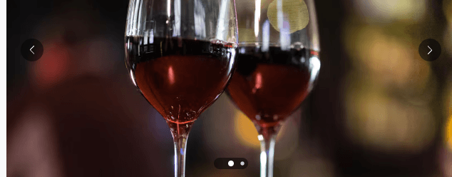 Two glasses filled with red wine against a dark, blurred background in Central Oregon.