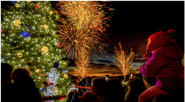 A crowd watches fireworks over a decorated Christmas tree at night in Central Oregon.