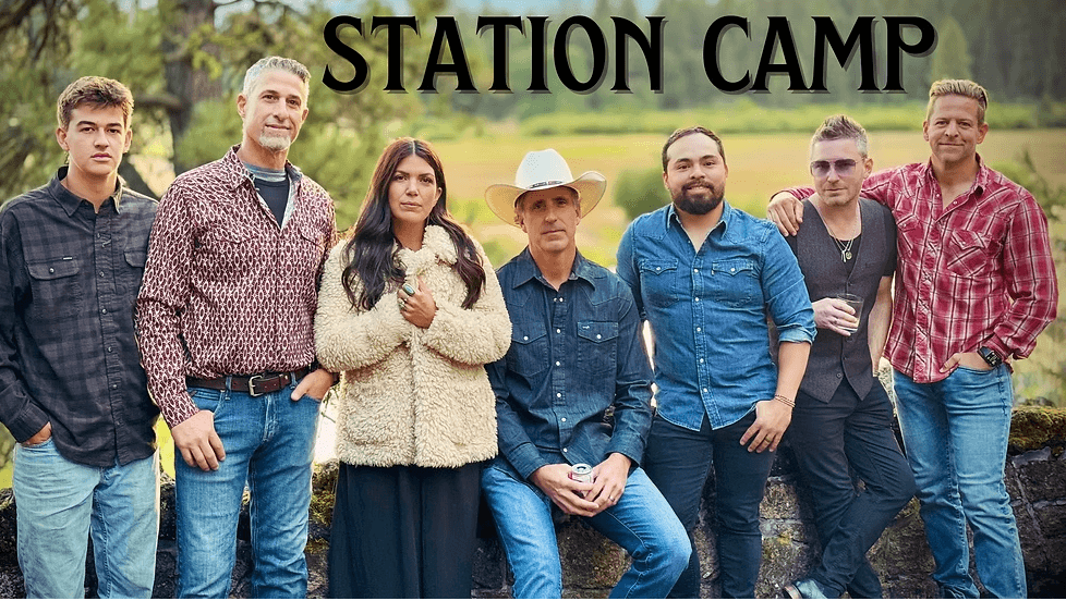 A group of seven people posing outdoors with the text Station Camp above them in Central Oregon.