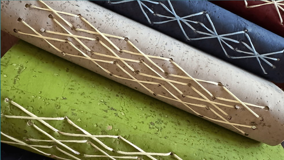 Close-up of three cylindrical objects with decorative cross-stitched lacing in Central Oregon.
