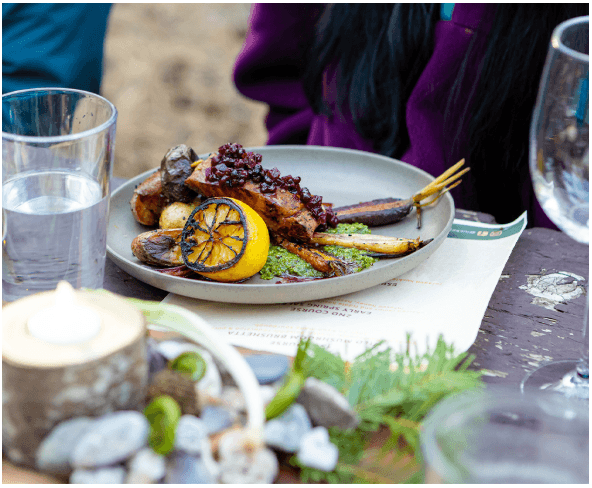 A plate of roasted salmon with vegetables and lemon on a restaurant table in Central Oregon.