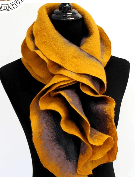 A ruffled, felted scarf in shades of mustard yellow and dark grey in Central Oregon.