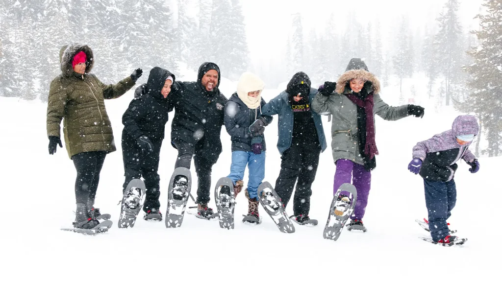 A group of people wearing winter gear and snowshoes standing in the snow in Central Oregon.