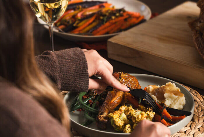 A person eating a holiday meal with turkey, mashed potatoes, and vegetables in Central Oregon.