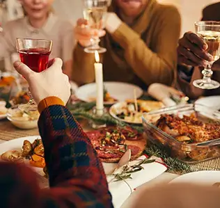 A group of people toasting with wine glasses at a festive dinner table in Central Oregon.