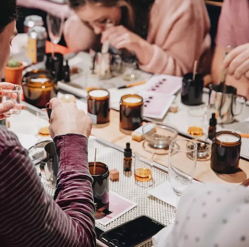 A group of people participating in a candle-making workshop at a table in Central Oregon.