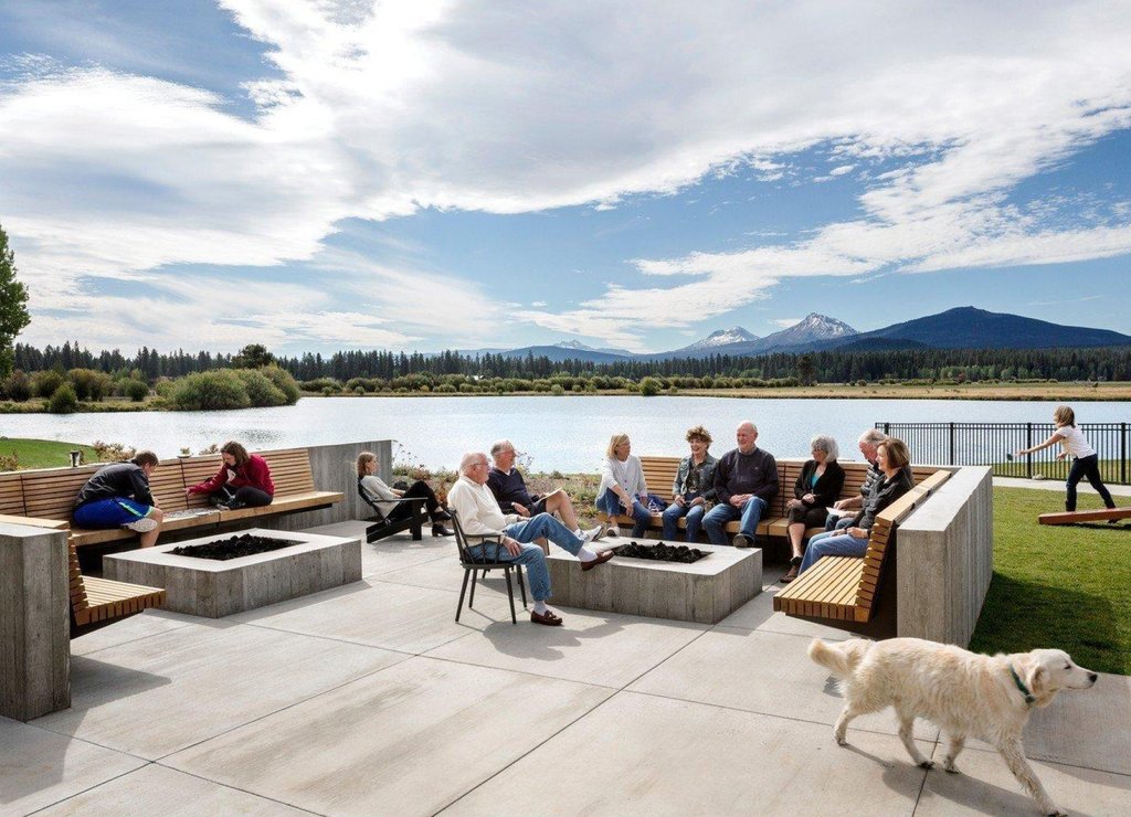 A group of people relaxing on a patio by a lake with mountains in Central Oregon.