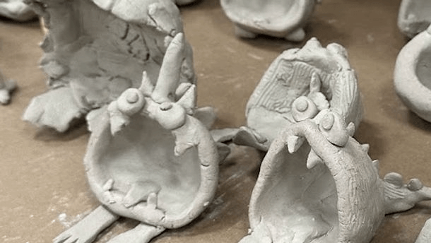 Several handmade clay monster sculptures with wide open mouths sitting on a table in Central Oregon.
