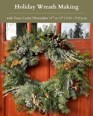 A festive evergreen wreath hanging on a red wooden door advertising a workshop in Central Oregon.