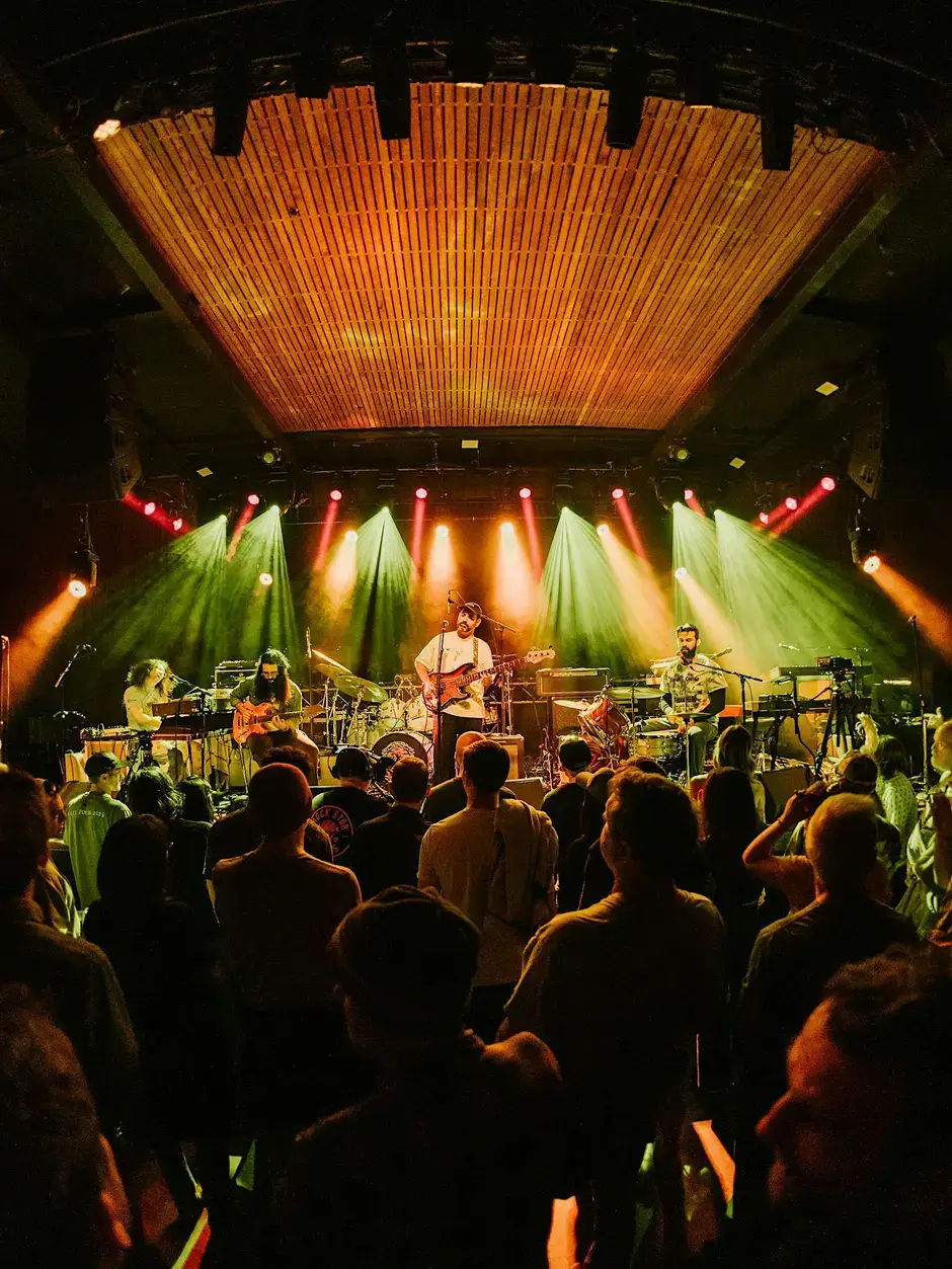 A band performs on a stage under dramatic lights before a crowded audience in Central Oregon.