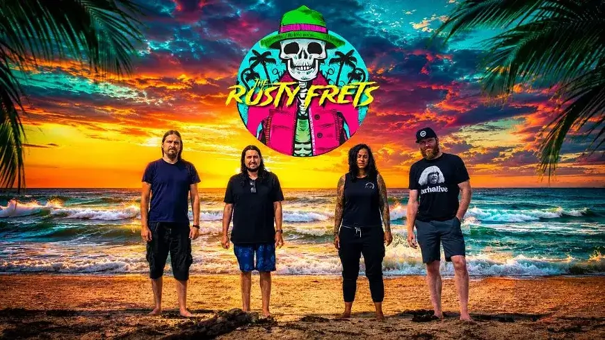 Four people standing on a beach in front of a vibrant sunset and band logo in Central Oregon.